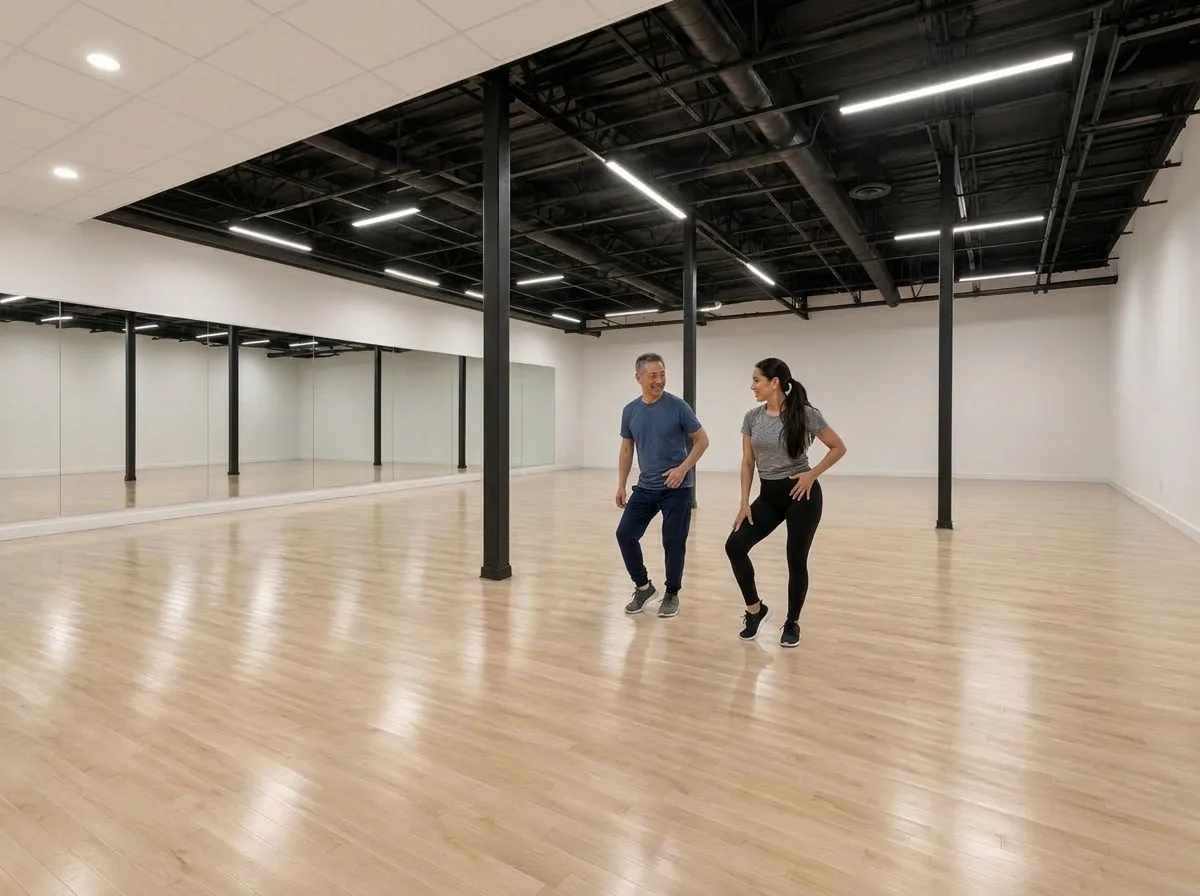 Instructor demonstrating cha cha technique with students in an Alhambra dance studio