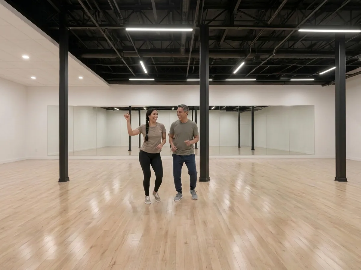 Instructor demonstrating samba technique with a student in an Alhambra dance studio