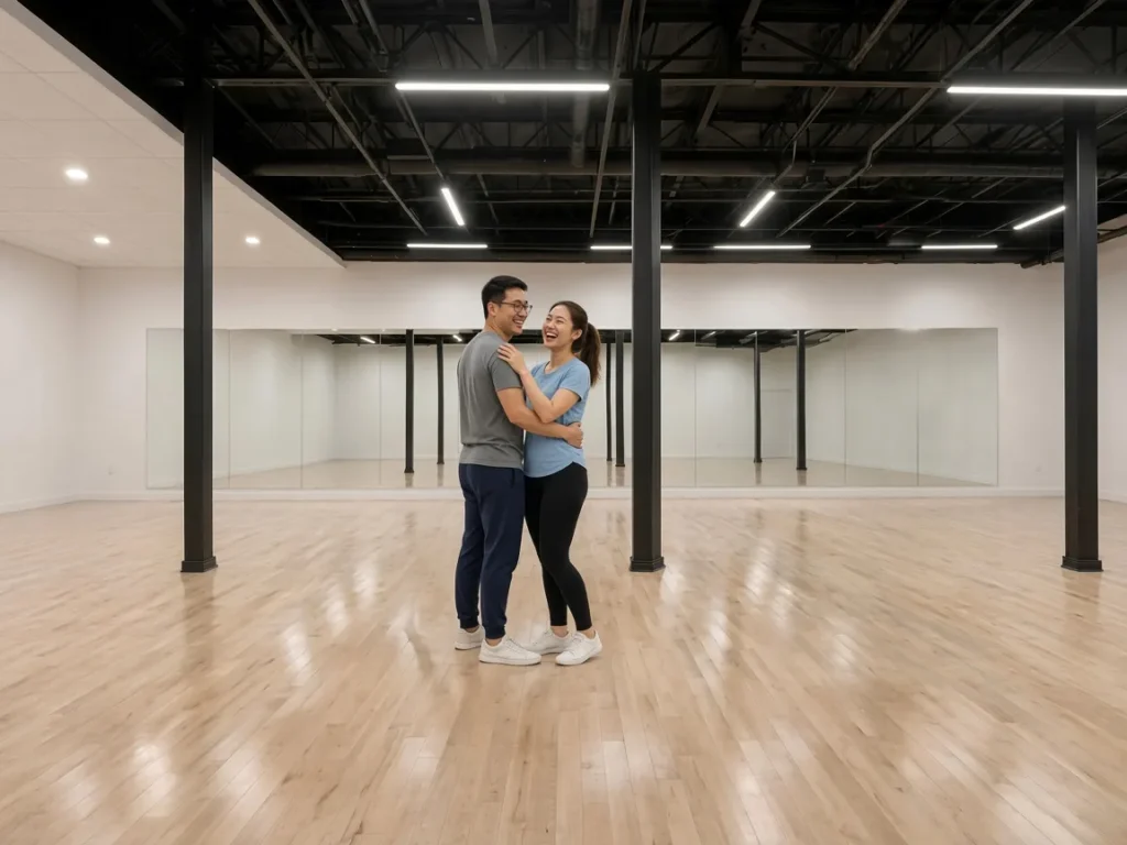 Engaged couple practicing their first dance together on a bright ballroom floor