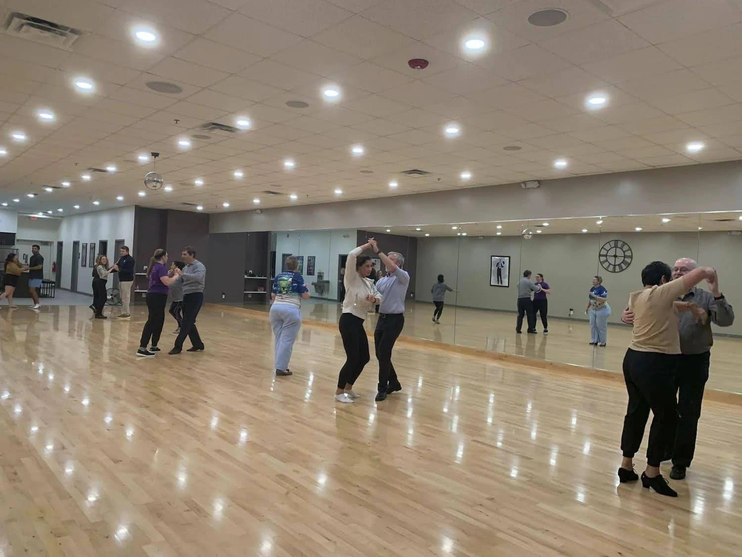 Couples practicing different types of ballroom dances on the studio floor at Fred Astaire Dance Studios – Ann Arbor, MI