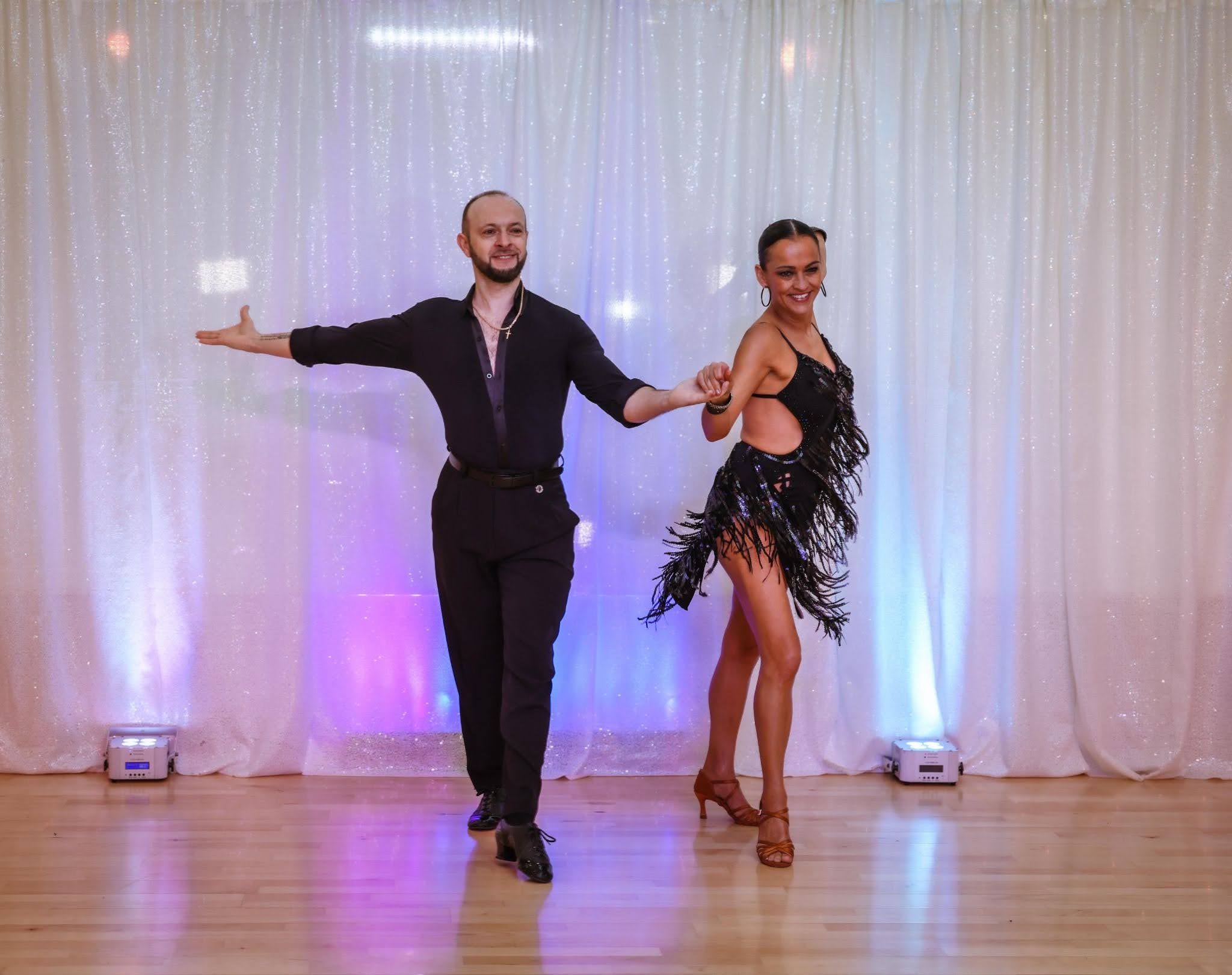 Couple performing a salsa dance routine during salsa classes in Apex, NC.