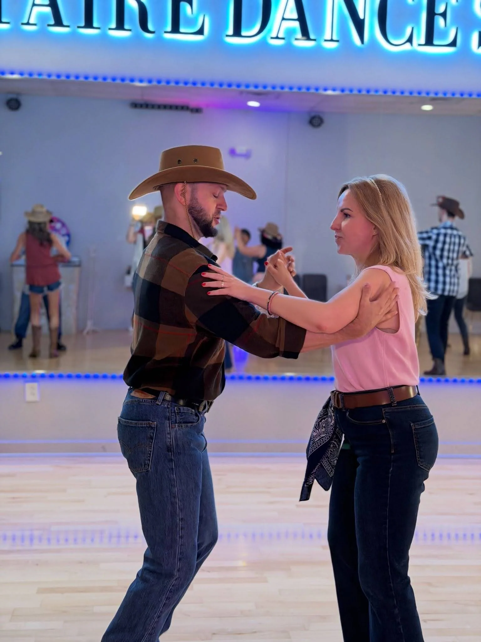 A couple learning their first dance steps through Adult Dance Lessons in Apex.