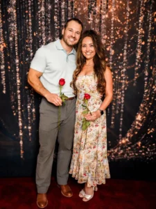 Reasons Couples Choose Dance Lessons: A smiling couple holds red roses while posing together, highlighting how dance lessons help couples build confidence, connect, and enjoy shared experiences.