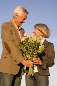 Senior couple man giving bouquet to woman