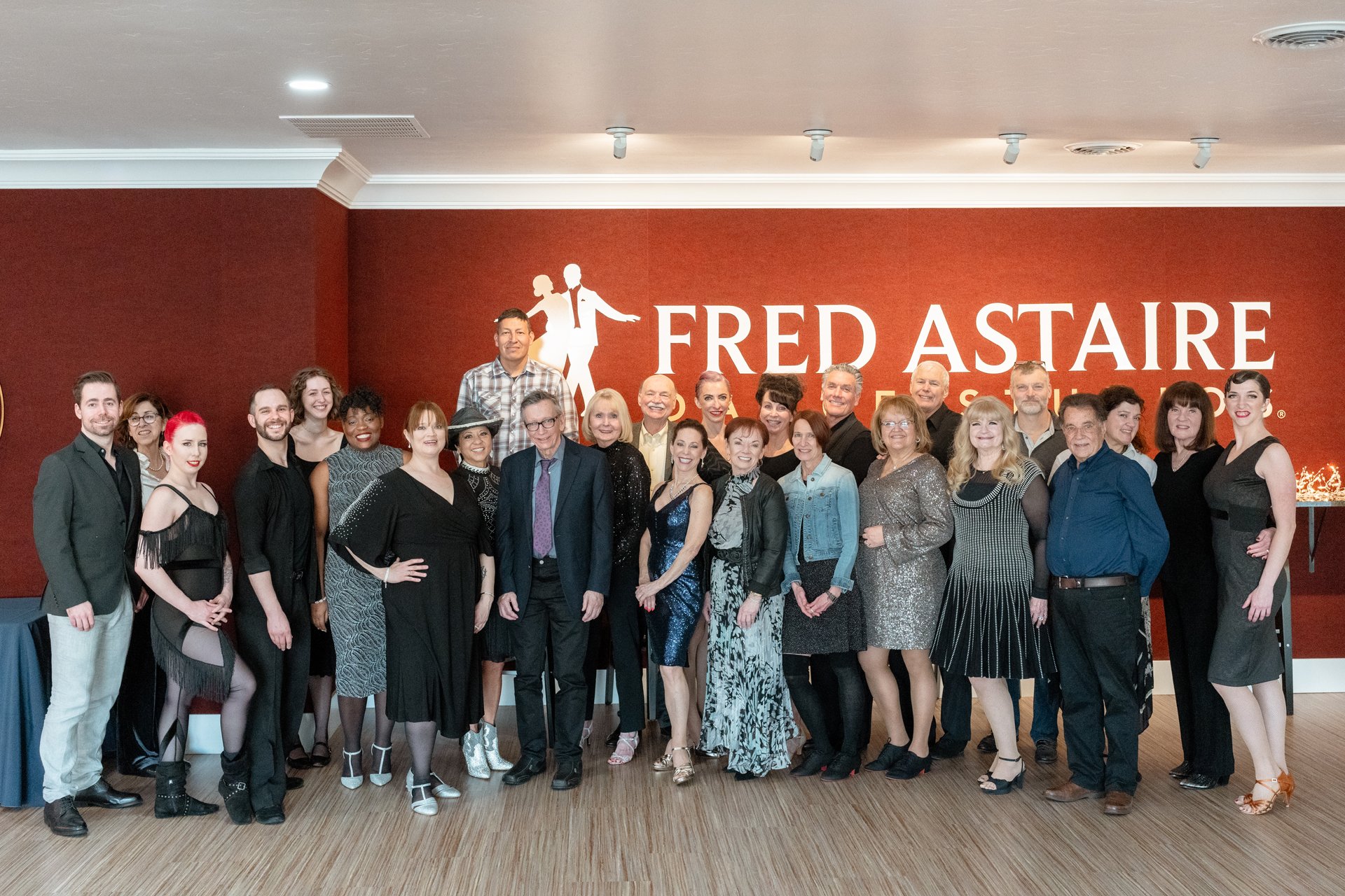 Fred Astaire dance studio members smile and pose in ballroom dance costumes in downtown Boise.