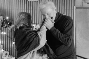Elderly couple slowdancing in living room.