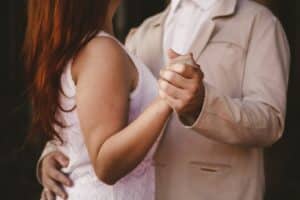 Young woman and man dancing slowly together.
