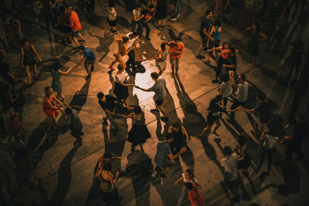 Aerial view of a crowd of people practicing various dance styles.