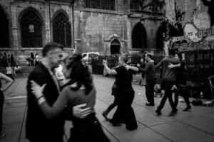 Group of dancing couples performing swing dancing in a city street.