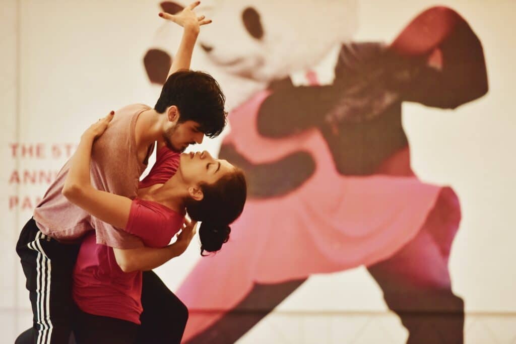 Young man and woman practicing the Salsa in a studio.
