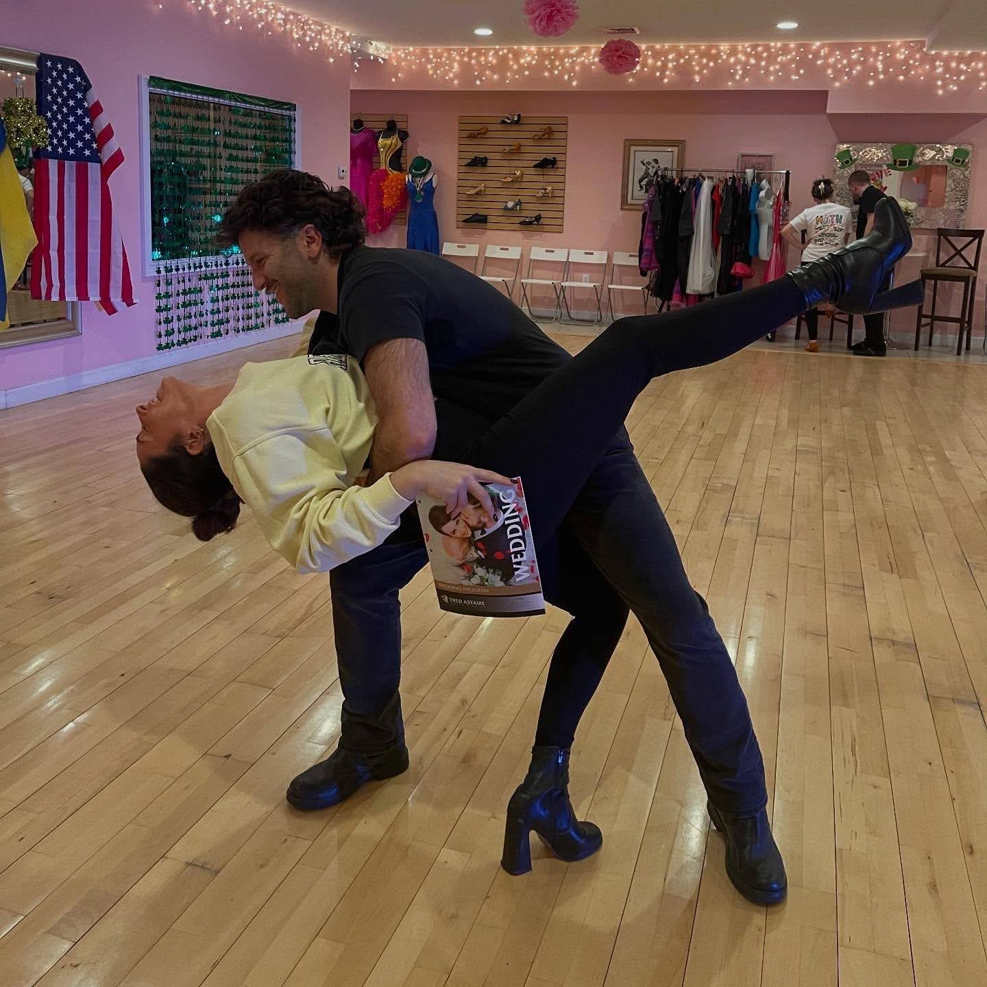 Couple practicing partner connection and movement during a lesson about the 5 fundamentals of salsa at a dance studio.