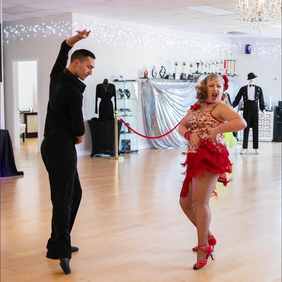 Two dancers performing Latin dances in a studio, showcasing expressive movement and rhythm.