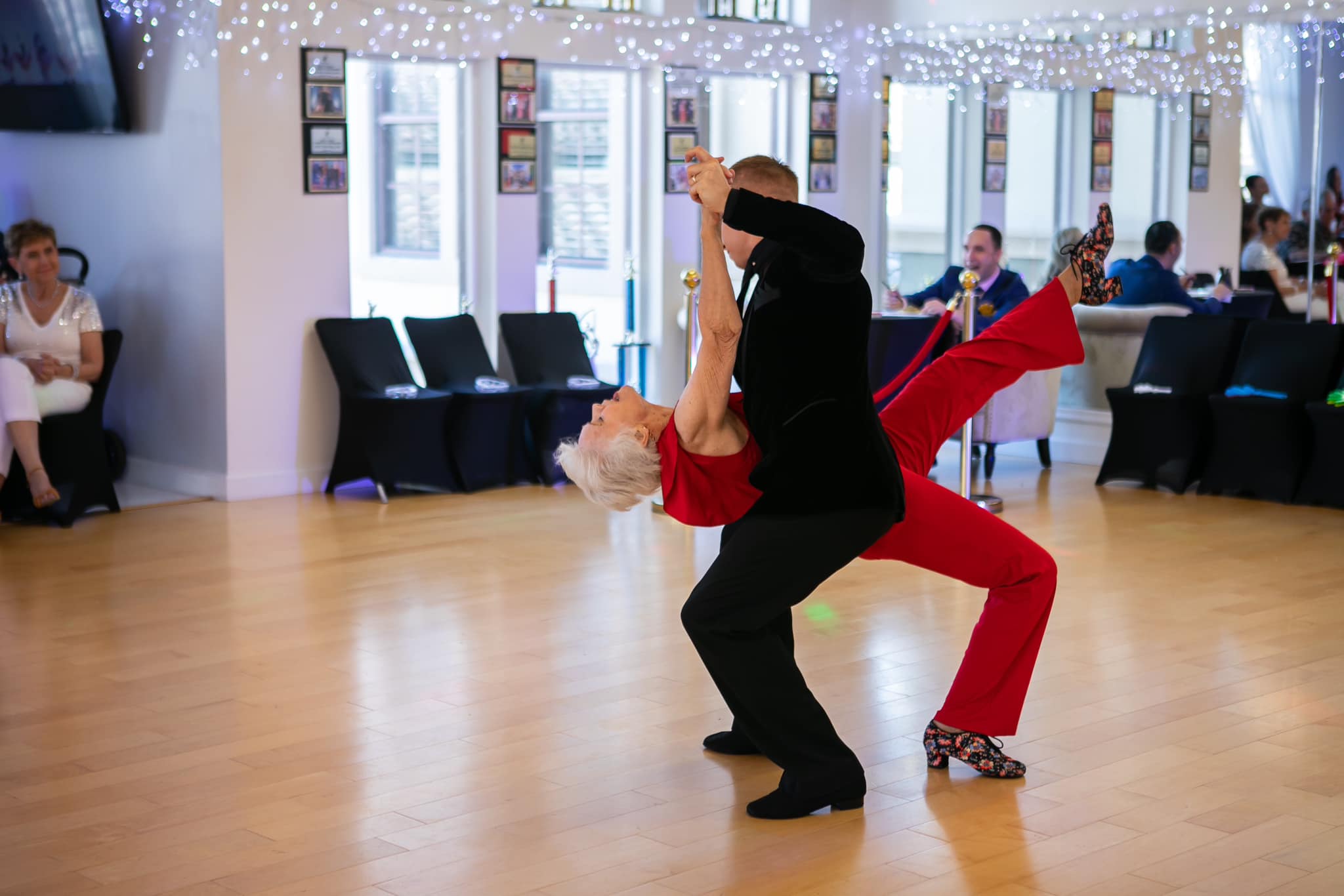 Couple performing a dance lift in a studio, showing how adults can learn to dance with confidence.