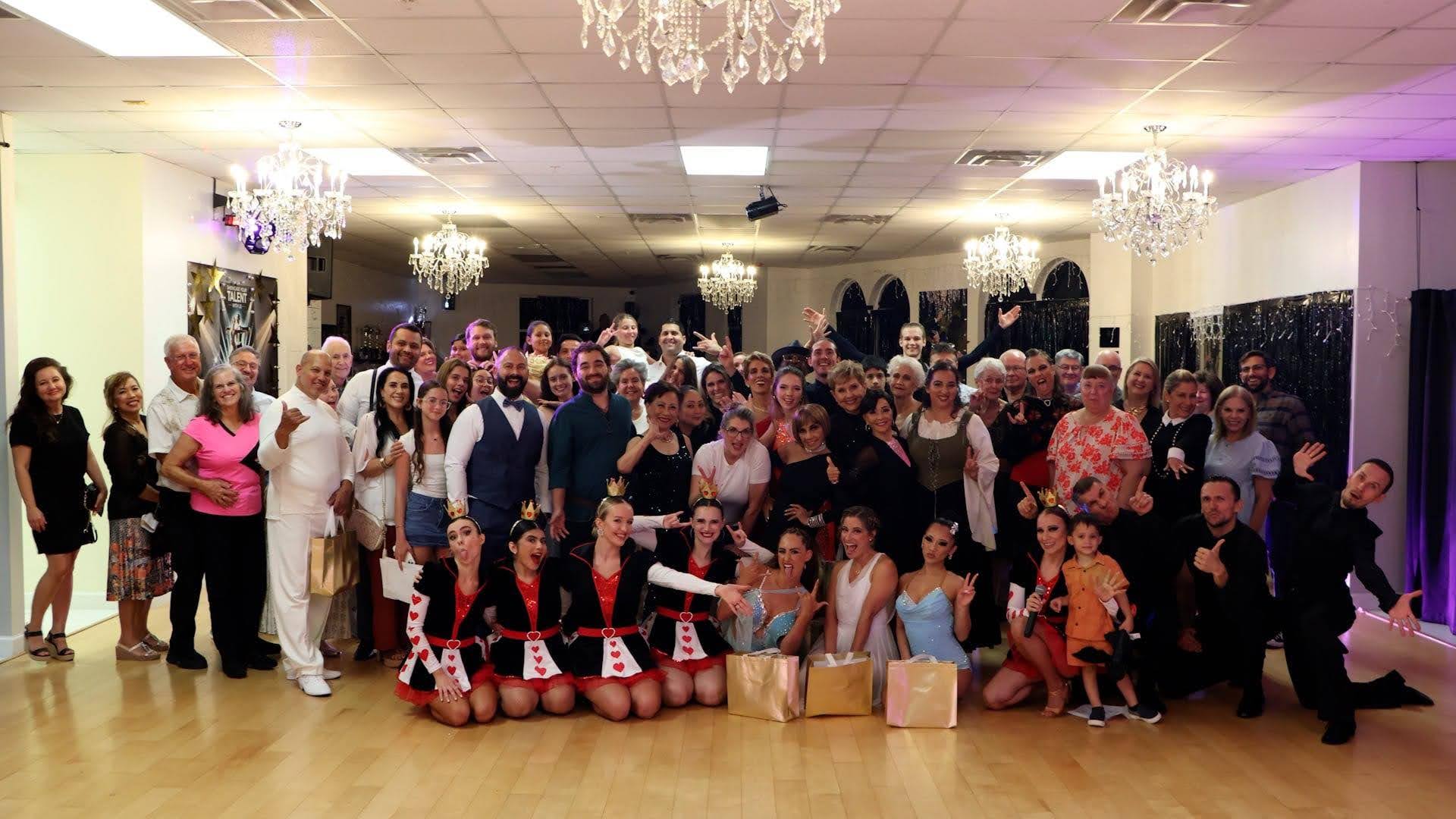 Group of ballroom dancers and students celebrating together at a dance studio, showing the benefits of ballroom dancing.