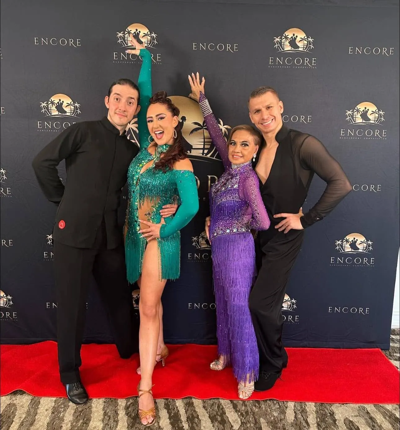 Four dancers posing on a red carpet at an Encore dance competition, showcasing colorful ballroom costumes and celebrating Fred Astaire Dance Studios.