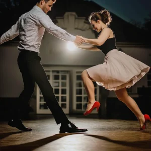 A man and a woman swing dance together on a ballroom dance floor.
This image is meant to complement the page titled Sing Dance Lessons.