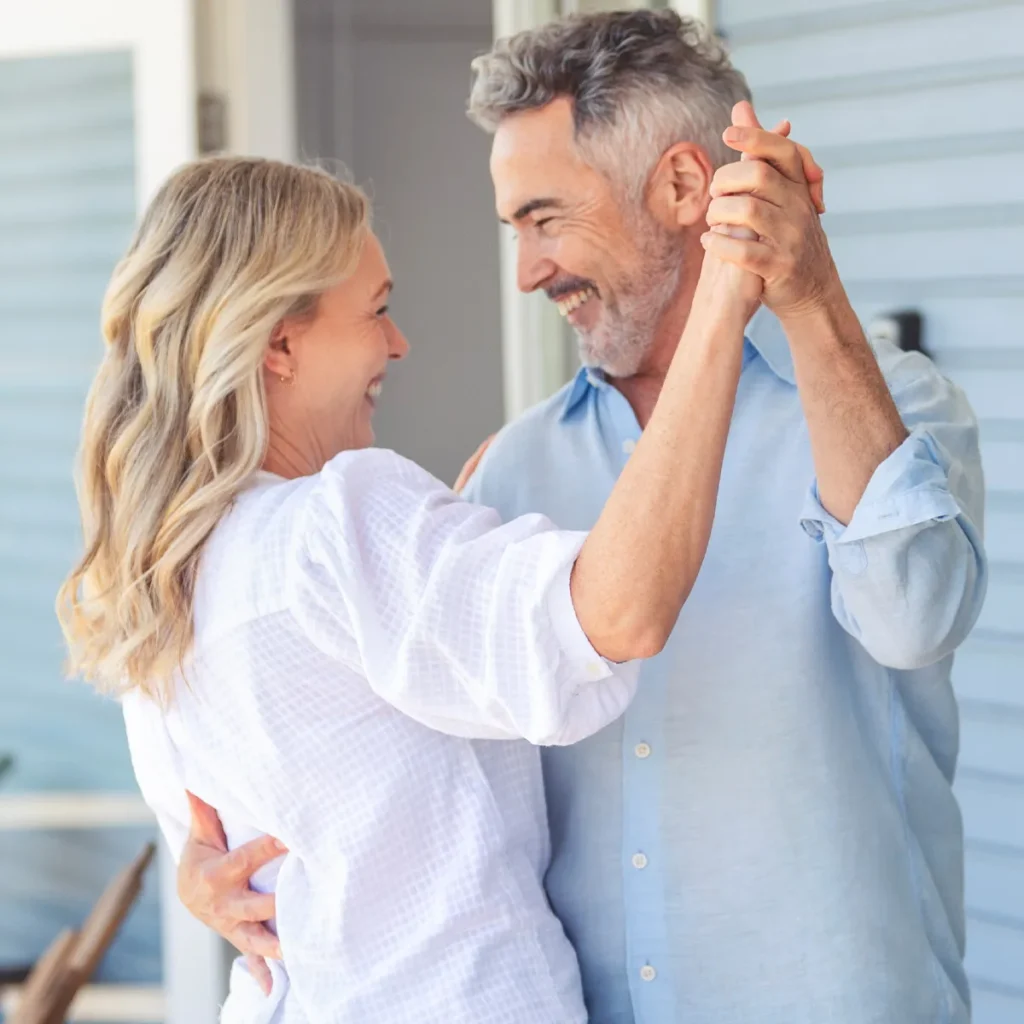 A woman in a white blouse and man in blue dress shirt take couples dance lessons in Durham.