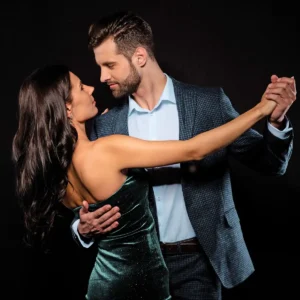 Man and woman in dress attire taking west coast swing dance lessons in Durham.