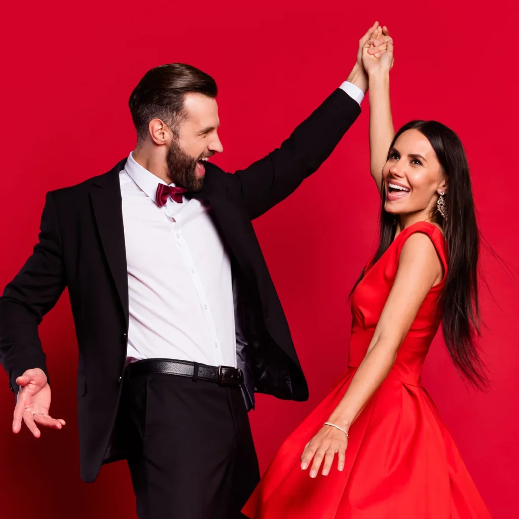 Woman in red dress takes Bolero dance lessons in Durham with her partner.