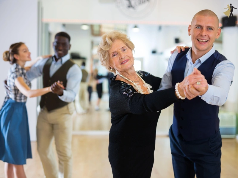 Smiling mature woman in pair ballroom dancing with young male instructor. The Tango is a favored dance style in Durham.