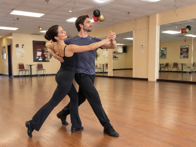 a couple in athletic clothing take foxtrot dance lessons at a Durham dance studio.