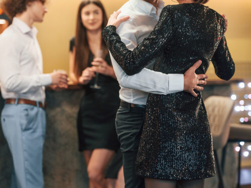Couple dancing, while friends are watching at them in the restaurant at party event.
