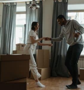 Young woman and male partner dancing in living room.