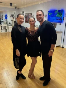 Common Beginner Mistakes in Dance Lessons: Three adults pose together in a dance studio, wearing practice and performance outfits while building confidence and improving their ballroom dancing skills.