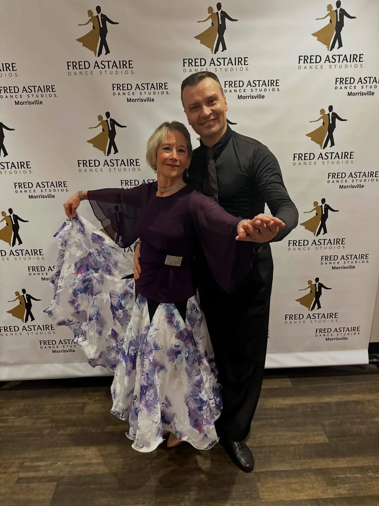 Benefits of Dance in Morrisville: A ballroom dance instructor and student pose gracefully in elegant attire at a Fred Astaire Dance Studios event, showcasing confidence, partnership, and the joy of dancing.