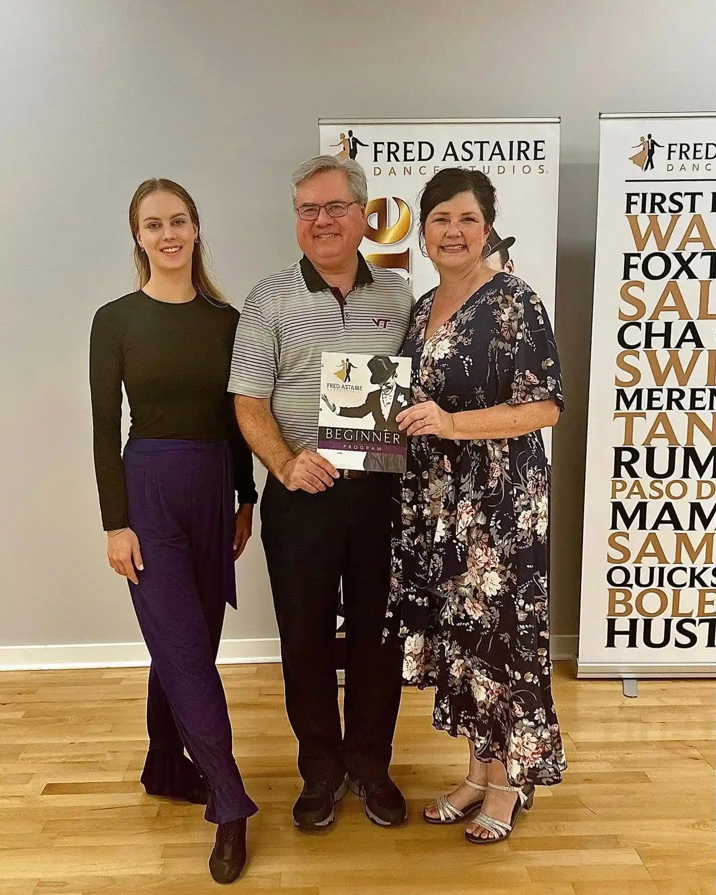 Three adults posing with a beginner dance program at Fred Astaire Dance Studios, highlighting how to Start Dancing in Morrisville.