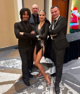 A group of ballroom dancers posing confidently in formal attire, illustrating how dance lessons can help overcome the fear of “I'll Look Stupid” and build confidence on the dance floor.