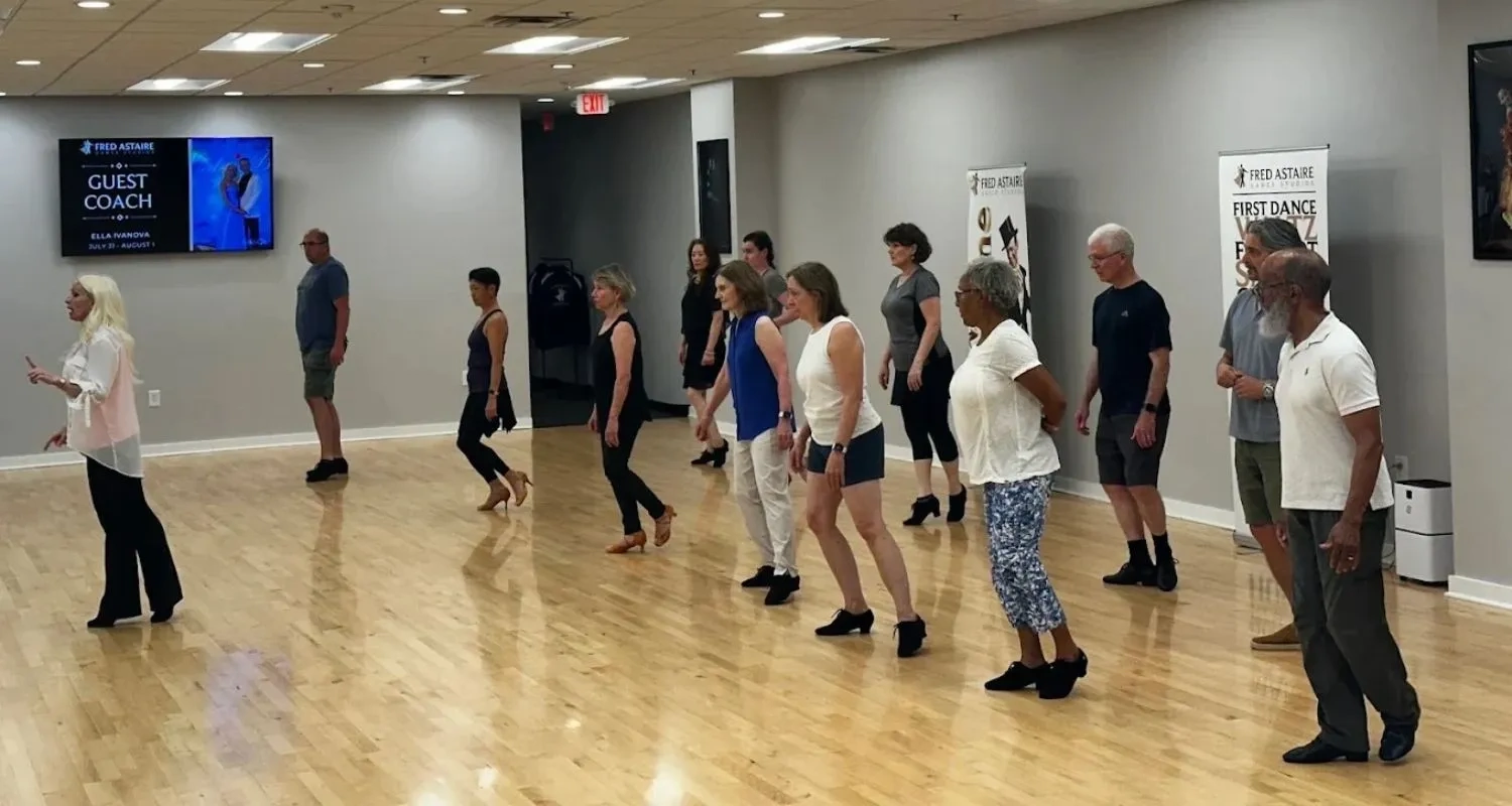 Adults in comfortable clothes at a group dance class, showing what to wear to dance class.
