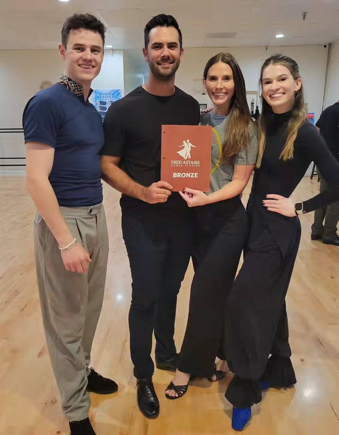 A photo with a beginner holding a certificate with his dance instructors after passing the Private Dance Lessons in Paradise Valley.