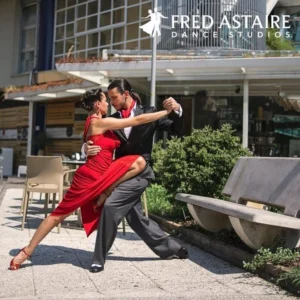 A couple performs a graceful ballroom dance outdoors, highlighting the personalized experience of Private Dance Lessons.