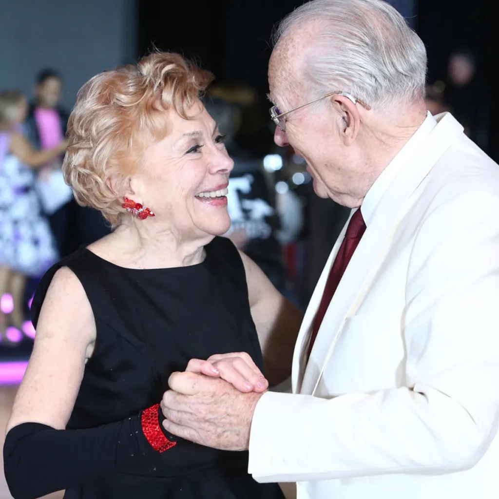 Senior man and wife dance in dress attire in a Raleigh dance studio.