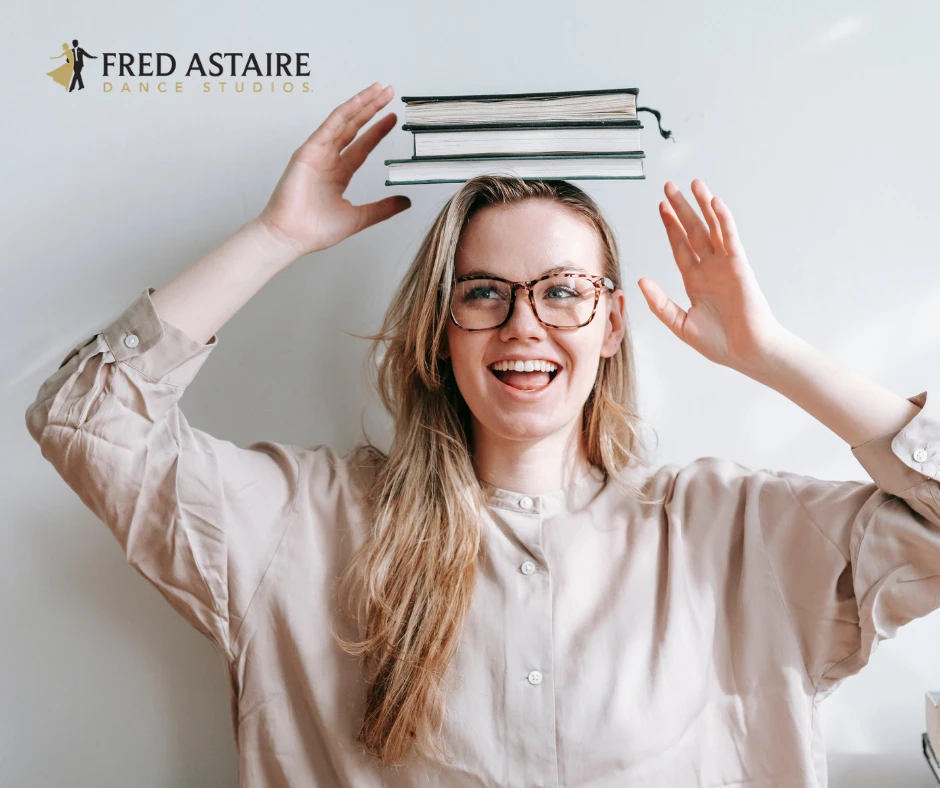 Woman practicing the book-on-the-head exercise to improve ballroom dance posture, balance, and body awareness.
