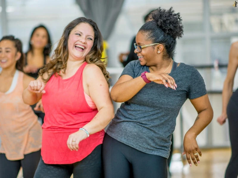 two ladies learn how to dance as an adult in a dance studio.