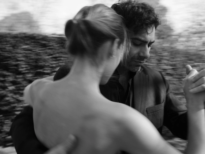 A couple gracefully dancing tango outdoors in a black and white photograph. Image complements the blog: How to Choose First Dance Song.
