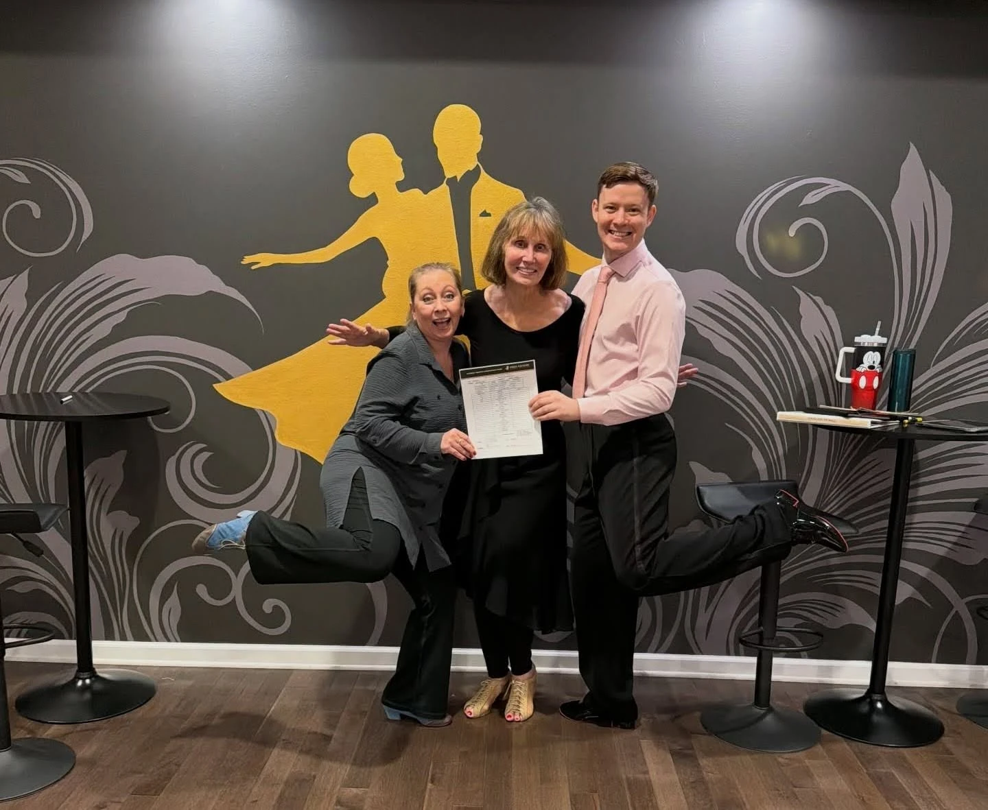 Dance students expressing their joy alongside their dance instructor after completing beginner's ballroom dance lessons in New York.