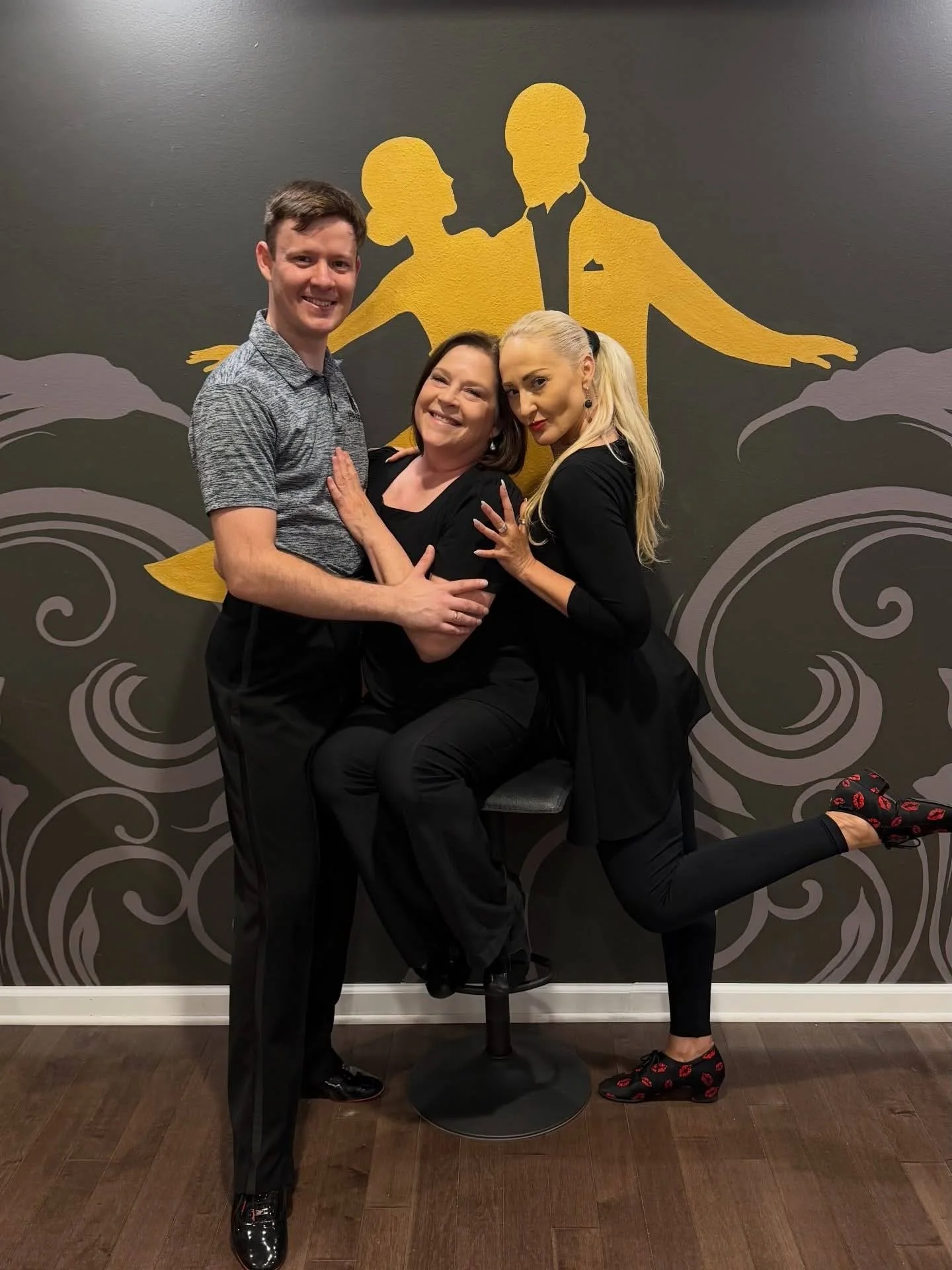 Three dancers pose together in a dance studio, showcasing a lively Latin dance position for Salsa dancing in Saratoga Springs.